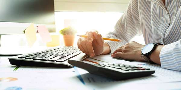 a man sitting at a desk using a calculator